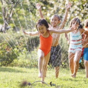 Children jumping through water fountain Children jumping through water fountain