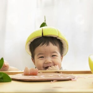 Photograph: green pear with cut top on a chocolate puddle, grapefruit half nearby